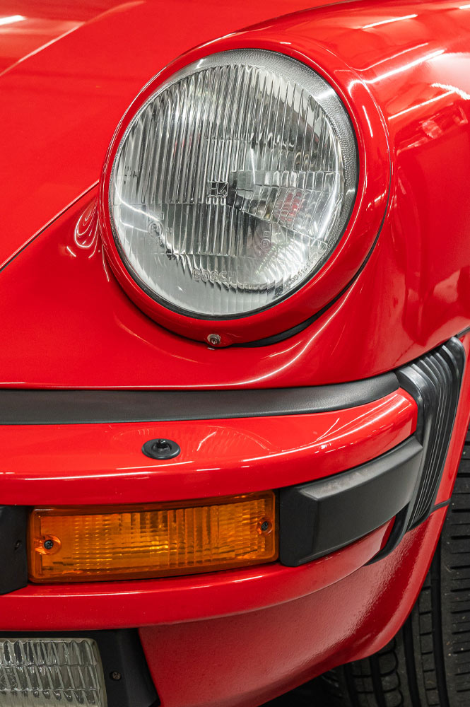 Typisches Porsche Frontlicht eines roten Porsches